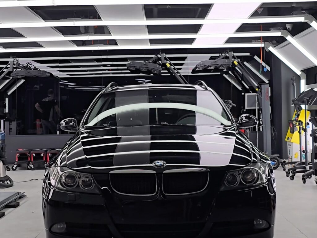 Відполірований чорний BMW після нанесення захисного воску в детейлінг-центрі.