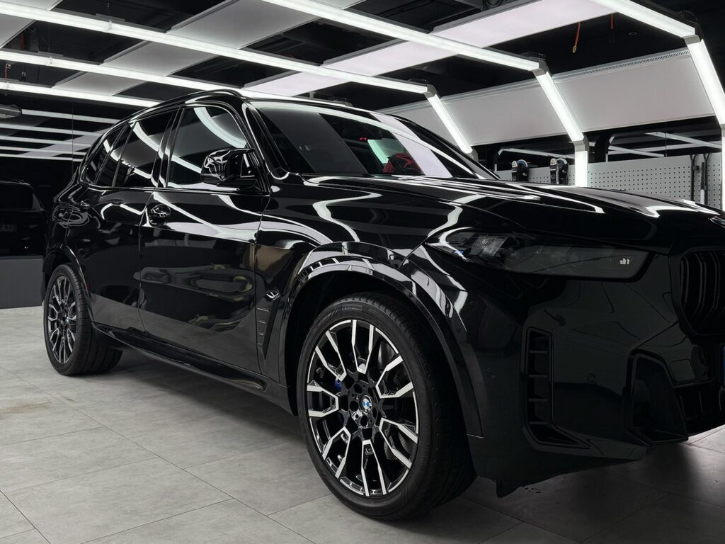 Чорний BMW X5 з ідеально полірованим кузовом у студії детейлінгу